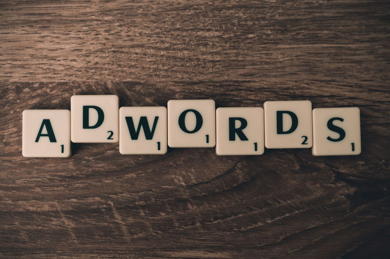 heros-img Scrabble tiles spelling AdWords on a wooden surface, symbolizing digital marketing concepts.